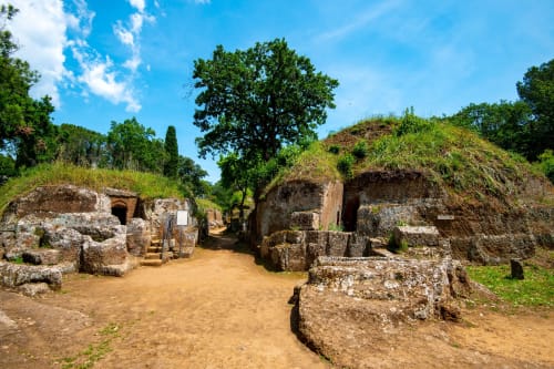 Antiche tombe etrusche con strutture in pietra e vegetazione vicino a Roma, Italia