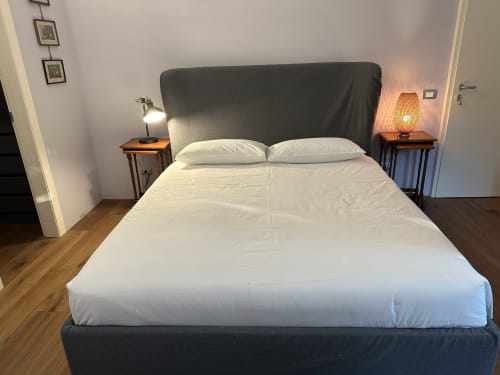 Camera moderna della Villa Dom hotel a Piacenza con letto matrimoniale, testata scura, biancheria bianca e comodini con lampade