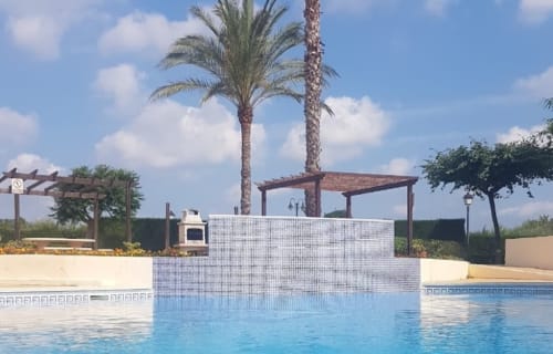 Piscina con estructura de azulejos y palmeras en Olivos del Sol, apartamento en Sant Jordi