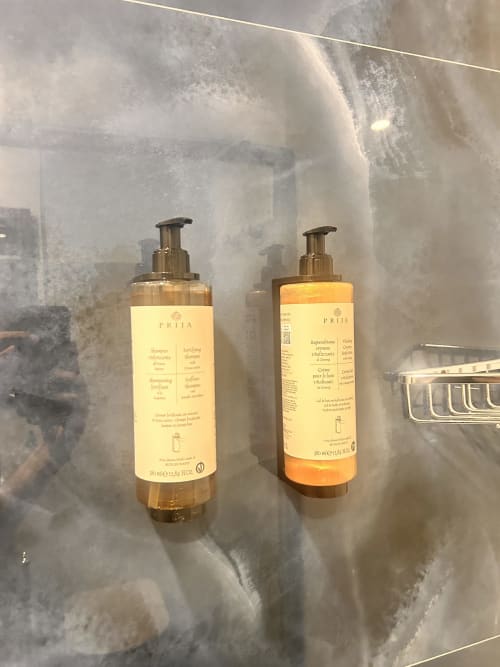 Flaconi di skincare PRIJA esposti nel bagno dell'Hotel Ercoli House, Roma