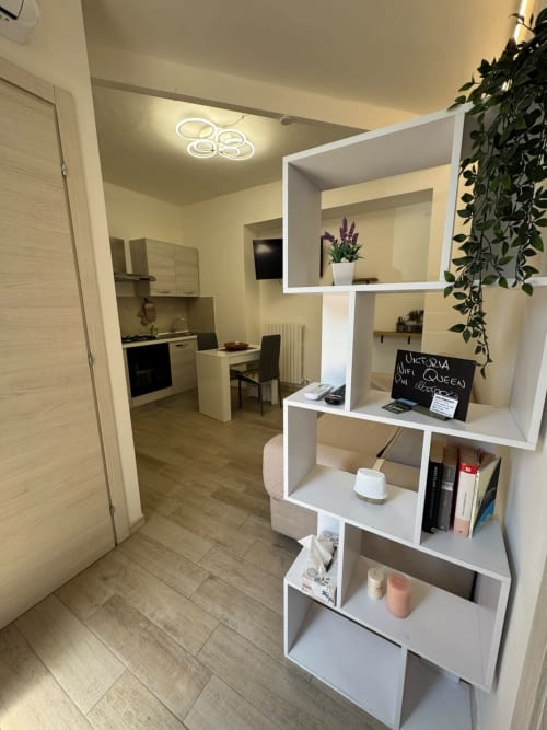 Victoria apartment in Campofilone with modern white shelving, kitchenette, and warm lighting