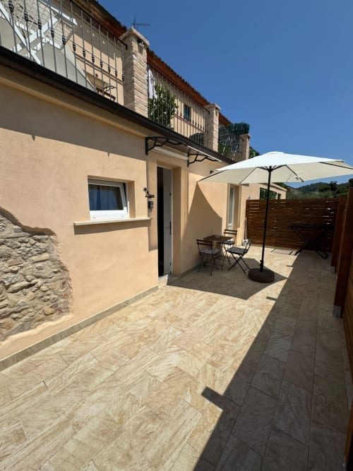 Terrazza dell'appartamento Victoria presso il Queen hotel a Campofilone con ombrellone, sedute e vista sulle montagne
