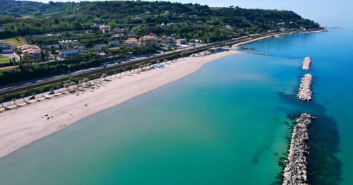Vista aerea dell'appartamento Victoria del Queen Hotel a Campofilone con spiaggia incontaminata, acque turchesi e frangiflutti in pietra