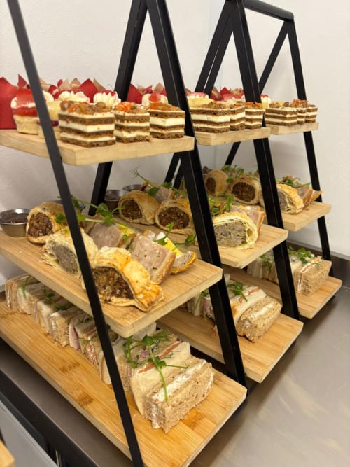 Three-tier tiered stand displaying gourmet sandwiches and layered cakes at The Old Kings Head, Kirton