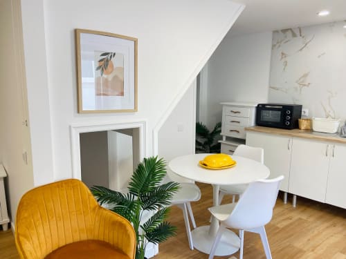 Moderna cozinha-sala de jantar na Casa das 7 Janelas em Peniche com mesa redonda branca, cadeira amarela e equipada