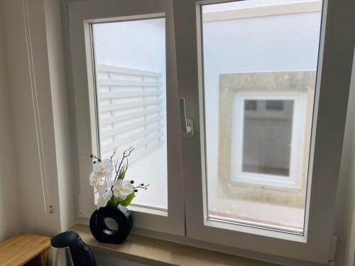 Janelas modernas com orquídeas brancas em vaso preto no hotel boutique Casa das 7 Janelas em Peniche, Portugal
