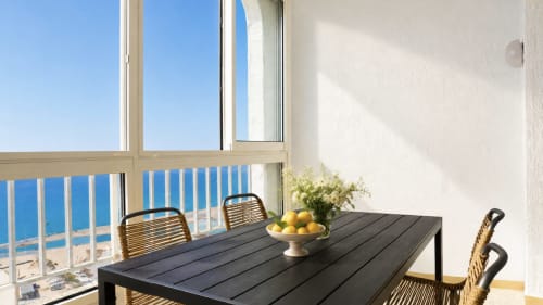 Comedor en balcón con vistas al mar en Holidays Manhattan, Empuriabrava: mesas, sillas y vista a la playa