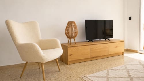 Sala de estar moderna en Holidays Costa Brava con sillón color crema, mueble TV de madera, televisor de pantalla plana y balcón con vistas al mar