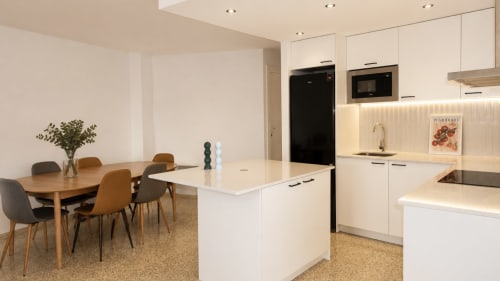 Cocina abierta y comedor moderno en apartamento Holidays Manhattan Sea View, Empuriabrava con mueblería blanca e isla