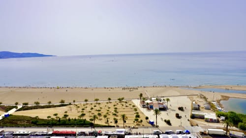 Playa de Empuriabrava con arena blanca, palmeras y vistas al Mar Mediterráneo desde Holidays Costa Brava