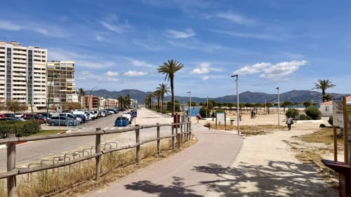Paseo marítimo de Empuriabrava con palmeras, apartamentos y playa en Holidays Costa Brava