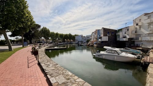 Paseo marítimo de Emporium Brava con embarcaciones amarradas y arquitectura mediterránea en Holidays Costa Brava