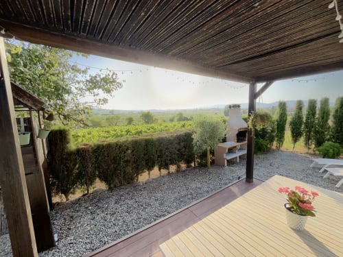 Terraza cubierta con tarima de madera con vistas a los viñedos en B&B Wine And Cooking Penedès, Barcelona