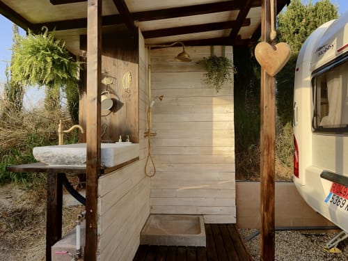 Ducha exterior en B&B Wine And Cooking Penedès de Barcelona con estructura de madera y lavabo de piedra natural