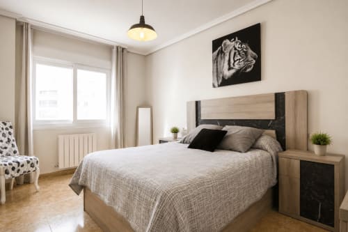 Dormitorio moderno en Riurau Home de Calp con cama de madera, detalles en negro, lámpara colgante y decoración contemporánea