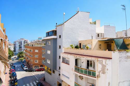 Edificio de apartamentos Riurau Home en Calp con fachada blanca, balcones y vista urbana bajo cielo azul despejado