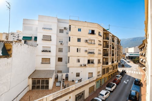Edificio de apartamentos Calp Riurau Home con vista a la calle, coches aparcados y arquitectura mediterránea