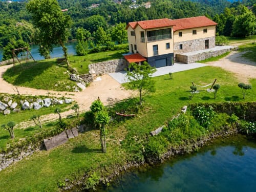 Casa Serração, chalé na região de Gerês com vista para lago em Rio Caldo, Portugal, cercado por gramados verdes e árvores