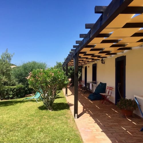 Pérgola com sombra no pátio da Herdade da Côrte em Tavira, Portugal, com deck em terracota, jardim e montanhas
