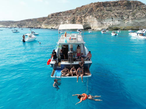 Turisti che nuotano e si rilassano in gita in barca presso Villa Dalila nelle acque turchesi di Lampedusa