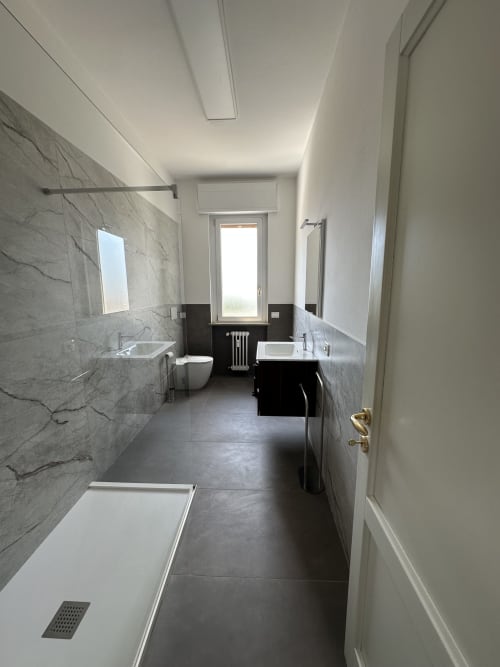 Moderno bagno nell'Apartment Skyview di 10 Minutes B&B a Verona, con rivestimenti in marmo, doppio lavabo, doccia e vista sulla città