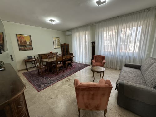 Ampio soggiorno nella B&B di Verona con zona pranzo, sedute e vista sulla città dalle finestre del balcone