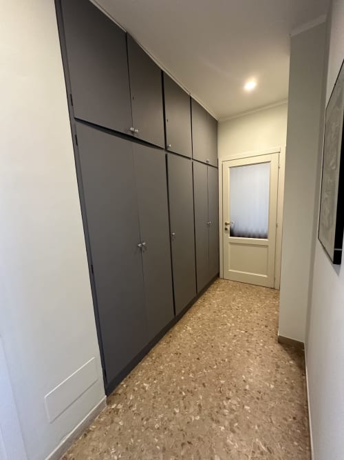 Corridoio moderno con armadi scuri incassati e pavimento in sughero presso Skyview Apartment a Verona B&B