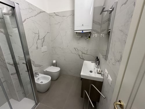 Moderno bagno nella Skyview Apartment del 10 Minutes B&B Verona, con piastrelle effetto marmo, toilette, bidet, lavabo e doccia
