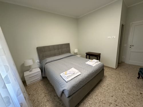 Camera luminosa in Skyview Apartment presso 10 Minutes B&B, Verona con letto grigio, comodini e vista sulla città
