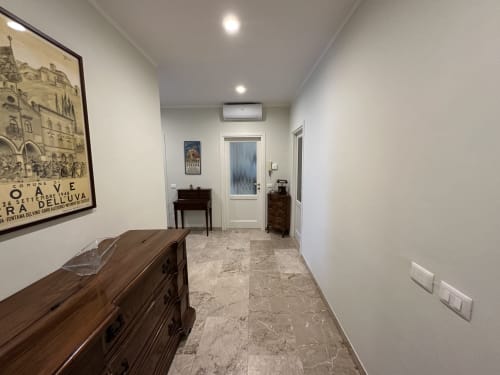 Corridoio moderno dell'appartamento B&B di Verona con pavimenti in marmo, arredi in legno e illuminazione contemporanea