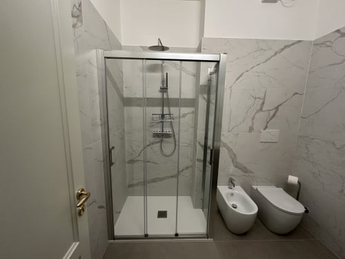Bagno moderno nel B&B di Verona con doccia walk-in, piastrelle in marmo, bidet e WC