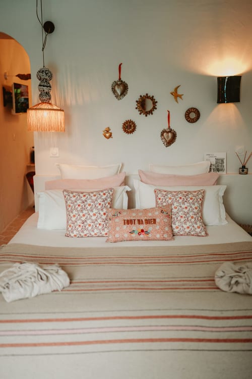 Chambre accueillante à la Bleu Guest House avec coussins corail, linge blanc et décoration murale à Saint-François