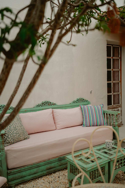 Lit de jour vert menthe orné avec coussins roses sur la terrasse Suite Bleu Lavande de la Bleu Guest House, Saint-François