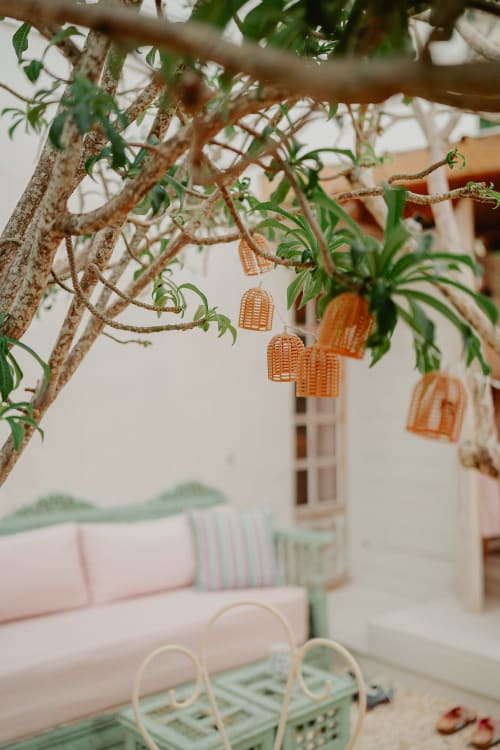 Des cages à oiseaux décoratives orange suspendues aux branches dans la Suite Bleu Lavande de la maison d'hôtes Bleu, Saint-François
