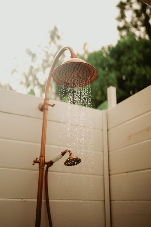 Douche extérieure avec robinetterie en cuivre à la Bleu Guest House à Saint-François, appartement Suite Bleu lavande avec vue sur le jardin