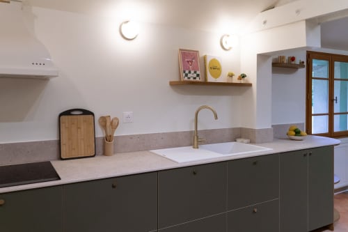 Cuisine moderne aux armoires vert olive et plan de travail blanc à la villa Maisons Noisette de Saint-Pierre-des-Ormes