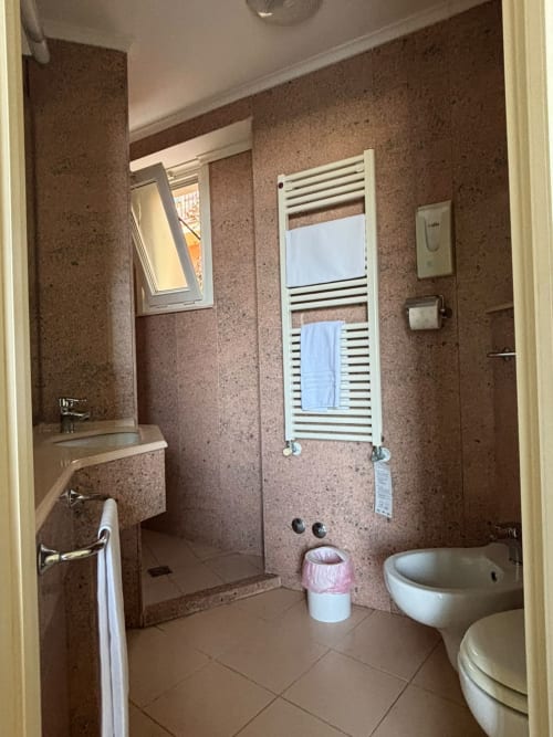 Salle de bains moderne à l'Hôtel Feluca à Bonassola avec murs en liège, douche, toilettes, bidet et sèche-serviettes chauffant