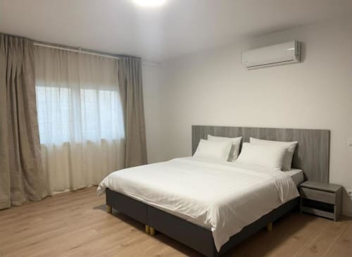 Spacious bedroom in Chaves villa with queen bed, garden view, air conditioning, and wooden floors