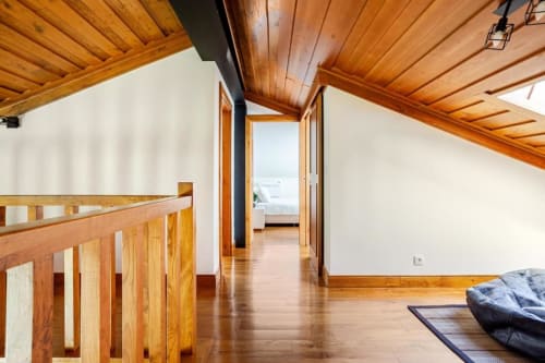 Wooden-ceiling hallway in Chaves villa with polished floors, wooden railings, and open doors leading to terrace views
