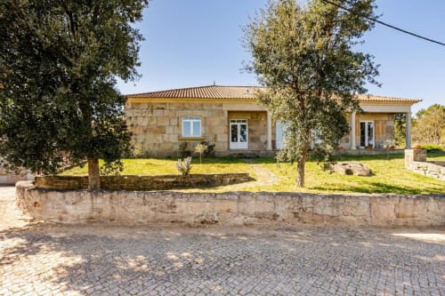 Stone villa with terrace in Chaves, Portugal, featuring garden views and mature trees in countryside setting
