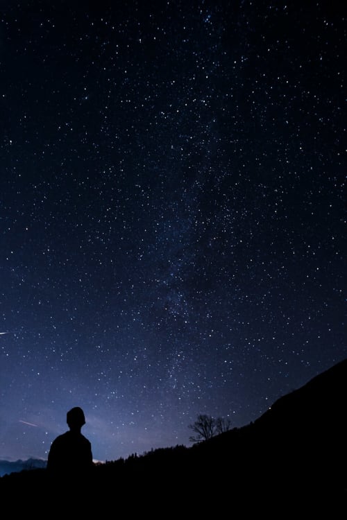 Silueta observando el cielo estrellado sobre el paisaje de Lyon, Hostal Yasi