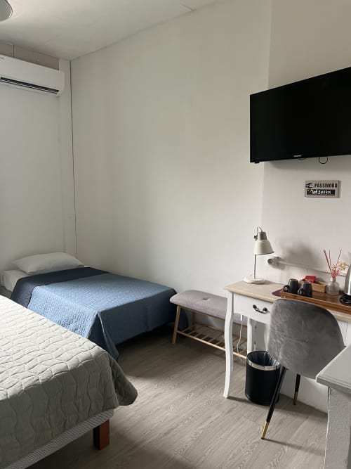 Chambre triple à l'Hôtel Les Paquebots à Port-Vendres avec deux lits, bureau, télévision et équipements modernes