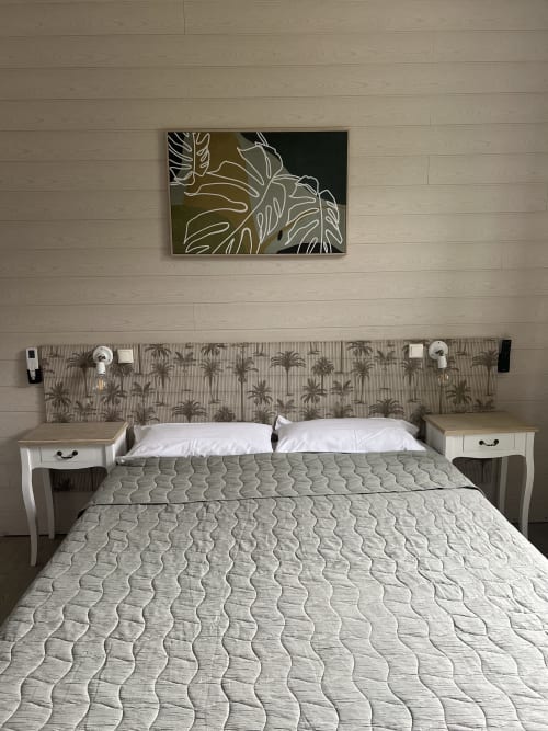Chambre moderne à l'Hôtel Les Paquebots à Port-Vendres avec lit matelassé, tête de lit motif palmettes et décoration murale botanique