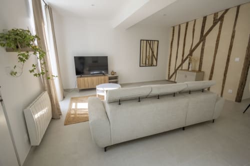 Séjour contemporain du gîte Chez Ninon et Lou à Châteaudun avec canapé beige, TV et vue sur la ville
