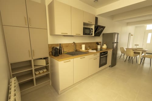 Cuisine moderne du gîte Chez Ninon et Lou à l'hôtel Accolade, Châteaudun, avec mobilier crème et appareils inox