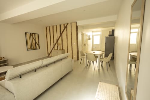 Séjour moderne du gîte Chez Ninon et Lou à l'hôtel Accolade, Châteaudun avec canapé crème, table à manger et vue sur la ville