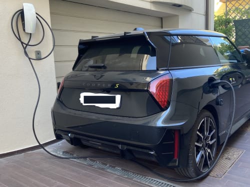 Black Mini Cooper S electric vehicle charging at Residence Aida hotel in Rimini, Italy