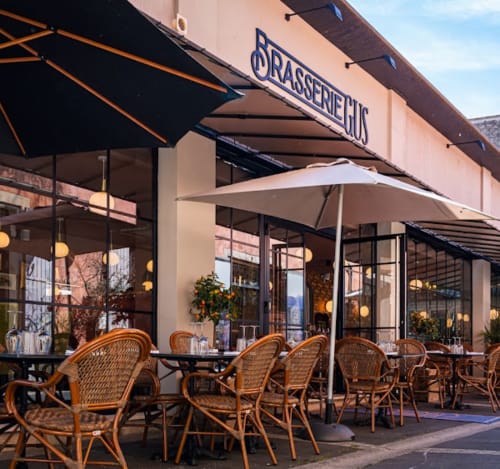 Brasserie HUG terrace at Mas 9 Romanin with wicker chairs and umbrellas in Saint Rémy de Provence