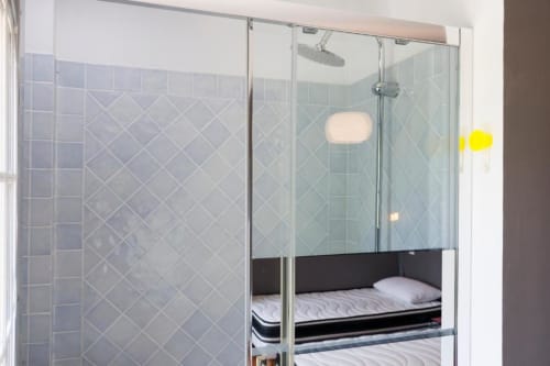 Salle de bains moderne avec douche vitrée et carrelage en motif diagonal au gîte Les Petits Toits à Galgon, France