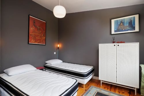 Chambre twin de la maison d'hôtes Les Petits Toits à Galgon avec deux lits simples, armoire blanche et décoration moderne